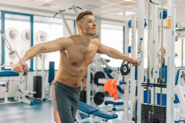 Fitness-istasyonda eğitim adam yan fotoğraf. Adam mükemmel bir gövdeye sahip. O yırtık olmak için çalışma dışarı gücü geliştirmek, kas tanım geliştirmek