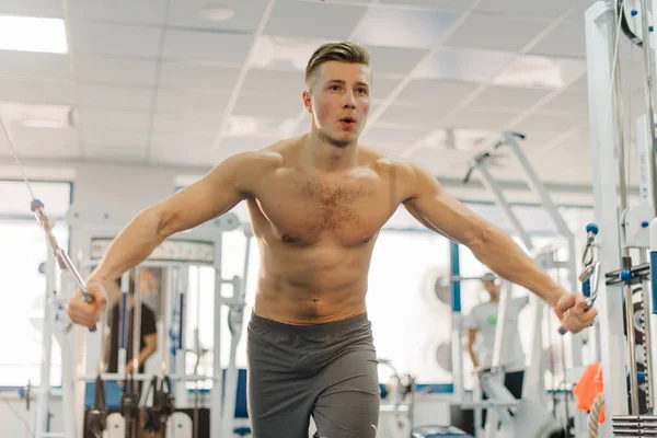 Entrenamiento de hombre muy fuerte en la estación de fitness. El tipo tiene manos fuertes. Trabajando para ser rasgado, desarrollar fuerza, desarrollar definición de los músculos — Foto de Stock