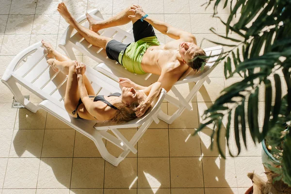 젊은 커플 수영장 근처 태양 침대에 편안 하 게 섹시 한. 소녀와 남자 여름 휴가 휴가입니다. 완벽 한 시체, 놀라운 곡선, 일몰 — 스톡 사진