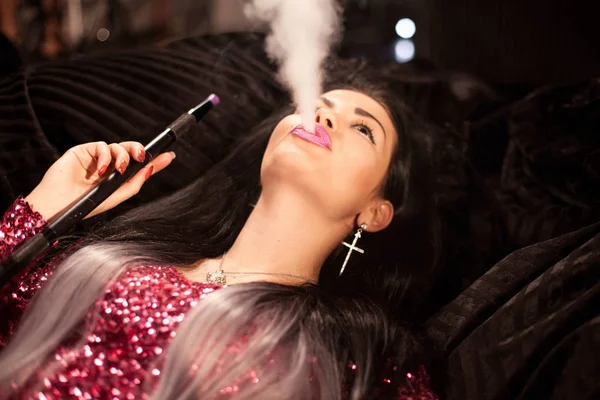 Όμορφη γυναίκα με ωραίο μακιγιάζ και χτένισμα εκπνέετε ναργιλές καπνού. — Φωτογραφία Αρχείου