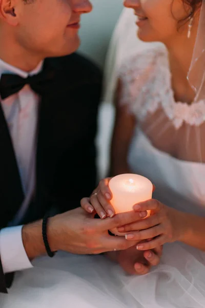 Die leuchtende Kerze in den Händen des Brautpaares. — Stockfoto