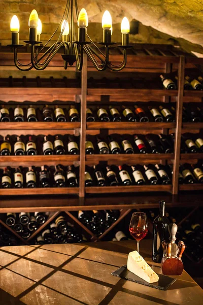 Il caveau del vino. Bella composizione di bicchiere di vino, formaggio e accessori su un tavolo di legno . — Foto Stock