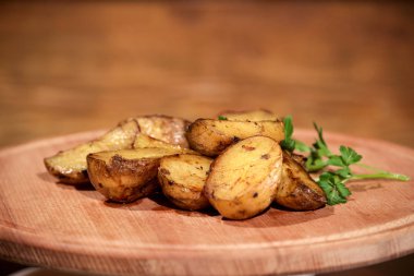 Bir ahşap tahta üzerine yerleştirilmiş otlar ile lezzetli kızarmış veya ızgara patates.