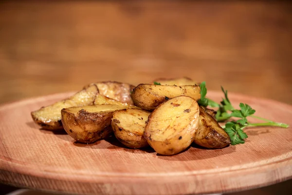 Bir ahşap tahta üzerine yerleştirilmiş otlar ile lezzetli kızarmış veya ızgara patates.