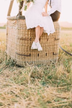 Airballoon hasır sepet üzerinde otururken bacak diz boyu gelinin elbise. Alan kompozisyon.