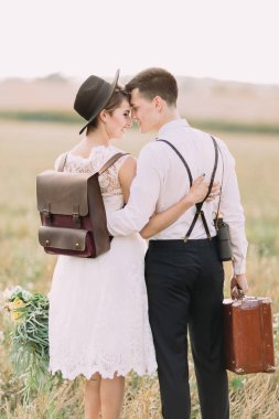 Kafa kafaya ayakta sarılma yeni evliler gülümseyen ve güneşli alanındaki in Rime ı zevk. Yakın çekim geri görüntülemek birkaç.