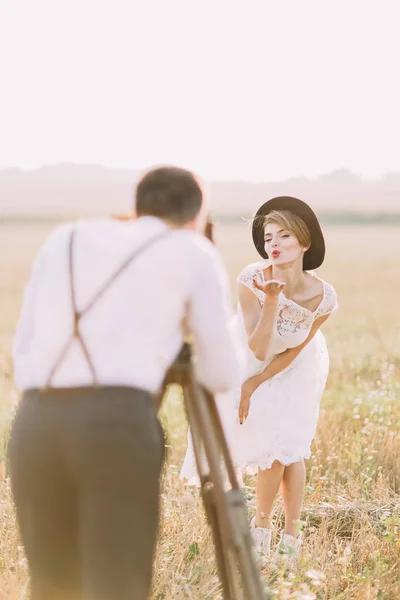 신랑 신부 써니 필드에 키스를 보내는 사진을 찍고 흐린된 후면 모습. — 스톡 사진