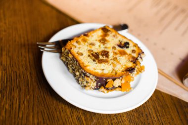 Çikolata ve fındık ile kaplı pastasından yakın çekim yan görünüm ahşap masanın üzerine yerleştirilen.