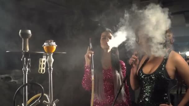 İki güzel kız eğleniyor ve bardaki nargile Sigara. — Stok video