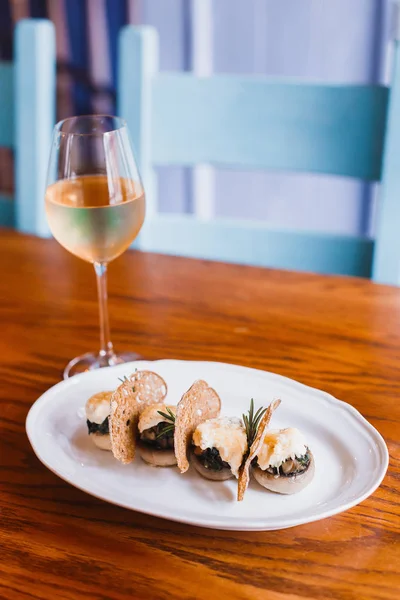 Peynir ve ahşap masanın üzerine yerleştirilen şampanya yakınındaki kurutulmuş ekmek ile mantar dikey fotoğraf.