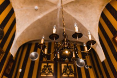 Avize formdaki görünümünü ters eski arka plan koyu duvara asılı mumlar.