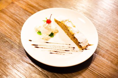 Elma meyveli turta ve dondurma nane ve kiraz ile taze krema ile yan görünüm.