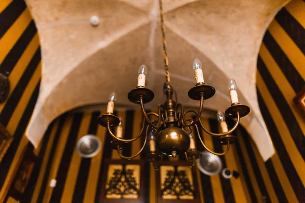 Avize formdaki görünümünü ters eski arka plan koyu duvara asılı mumlar.