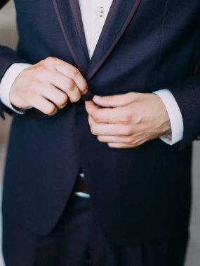 Damat Düğün ceket kadar düğmelerini elinde görünümünü yakın çekim.