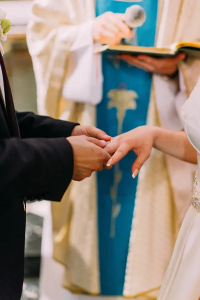 De ceremonie van het huwelijk. Bruidegom zet de trouwring op de vinger van de bruid. — Stockfoto