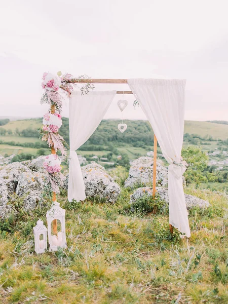 Lovely decorated wedding arch with pink flowers and herbs placed at the background of the mountains. — Stock Photo, Image