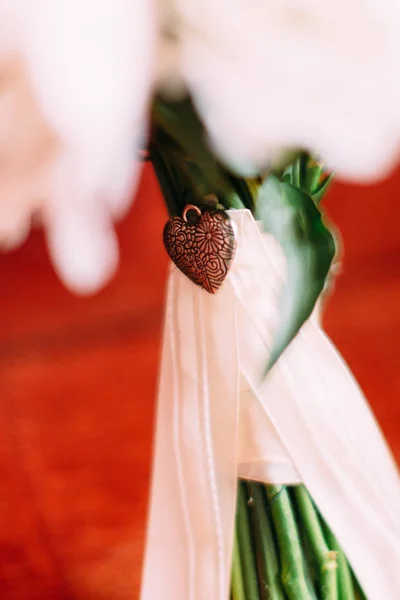 Vas szív díszíti az esküvői csokor. — Stock Fotó