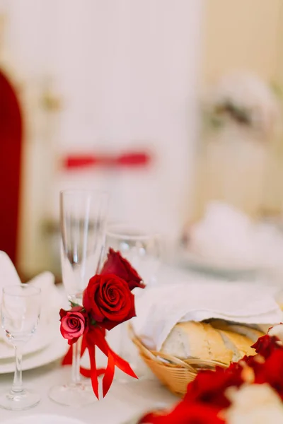 Vista de perto da taça de champanhe decorada com rosas vermelhas e fitas . — Fotografia de Stock