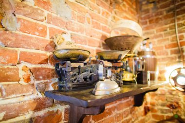 Demir, antika ağırlık, varil ve eski yemekleri yan görünüm tuğla duvar ahşap raflara yerleştirilmiş.