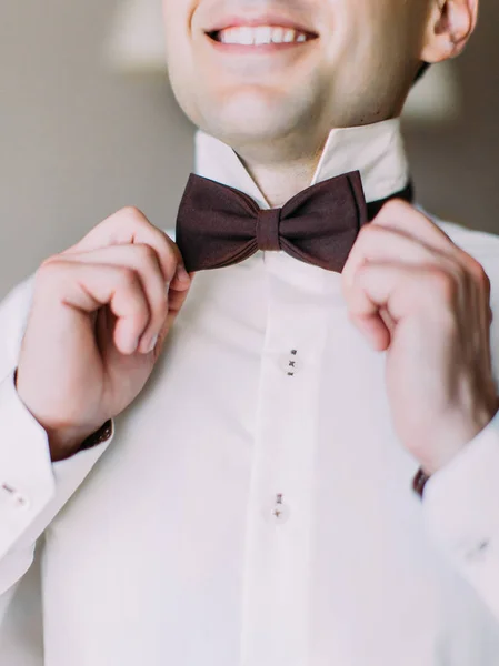 Close-up view of the hands of the groom correcting the bow-tie. — Stock Photo, Image