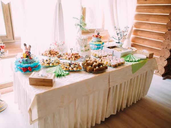 The view of the table set full of diffeerent cakes, cupcakes and wedding cake. — Stock Photo, Image