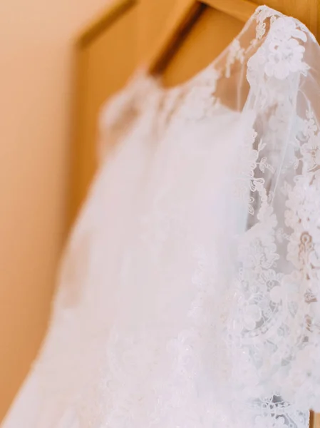 La vista lateral del vestido de novia colgando de la percha . —  Fotos de Stock