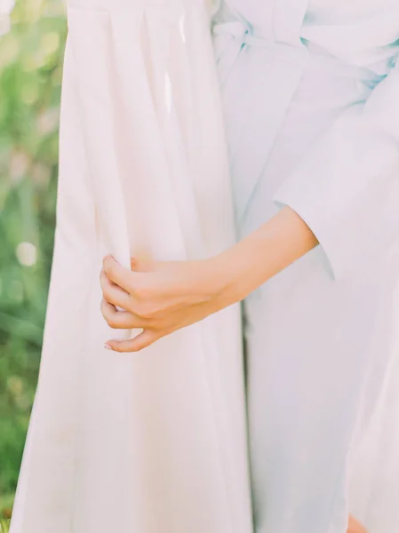 Las manos de la novia están tocando el vestido de novia de seda. Vista de primer plano . —  Fotos de Stock