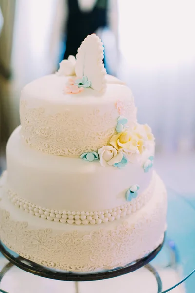 Bunte Blumen schmücken die weiße Hochzeitstorte. — Stockfoto