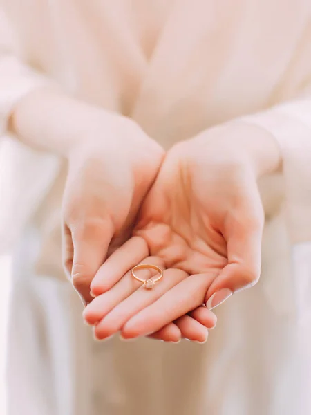 Невеста держит золотое обручальное кольцо . — стоковое фото