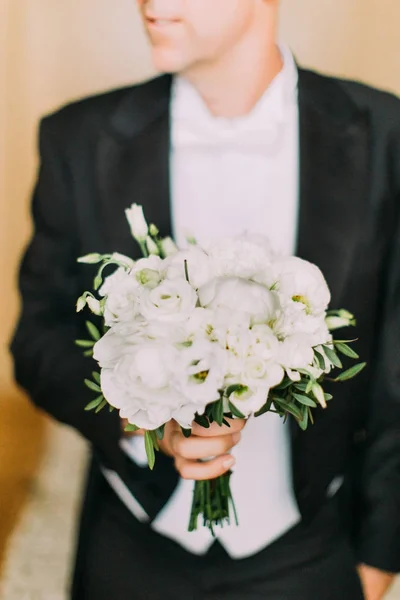 Maravilhoso buquê de casamento de peônias brancas nas mãos do noivo . — Fotografia de Stock
