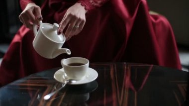 Çay Kupası ve içme dökülen Kırmızılı kadın elinde yakından görmek. Cafe konumu.
