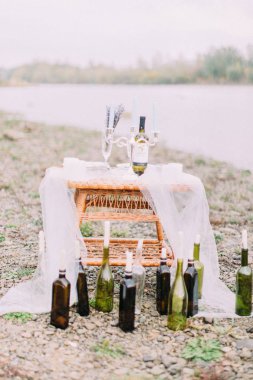 Sahilde dokuma masada mumlarla şişe oluşan romantik kompozisyon yakından görmek yerleştirilir.