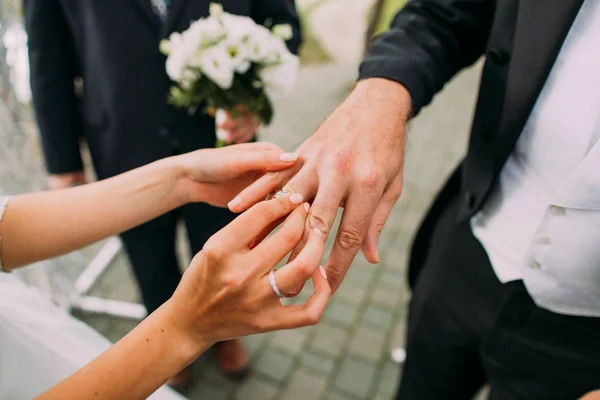 Невеста надевает обручальное кольцо на палец жениха. Свадебная церемония под открытым небом . — стоковое фото