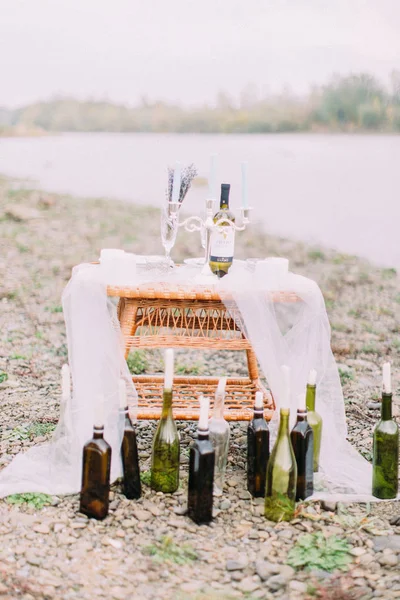 Sahilde dokuma masada mumlarla şişe oluşan romantik kompozisyon yakından görmek yerleştirilir.