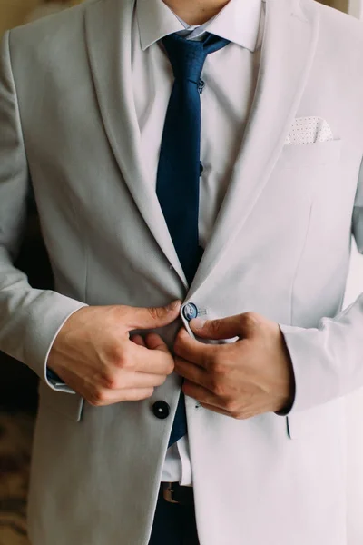 Vista de perto das mãos do noivo abotoando a jaqueta . — Fotografia de Stock