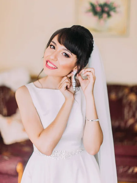 Ritratto a mezza lunghezza della sposa sorridente che indossa gli orecchini . — Foto Stock