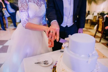 Yeni evli çiftin düğün pastası ilk parçası. Eller yakından görmek.