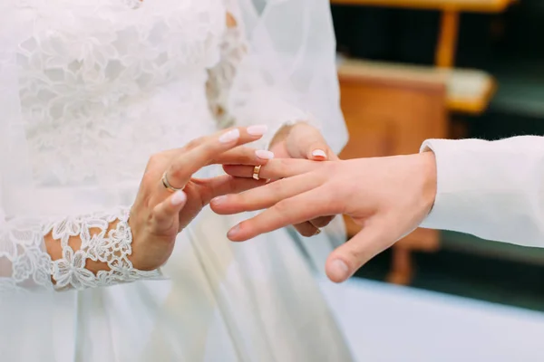 Close-up photo of the hands of the bride putting the wedding ring on the finger of the groom. — Stock Photo, Image