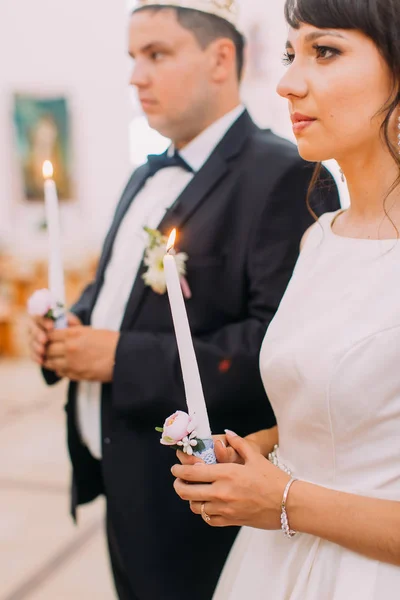 Побочный портрет счастливой молодожены, держащей свечи во время свадебной церемонии . — стоковое фото