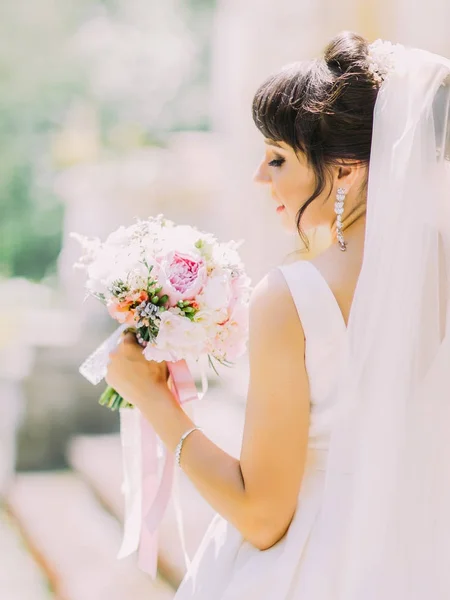 A vista de trás close-up da noiva encantadora segurando o buquê de casamento de peônias coloridas . — Fotografia de Stock