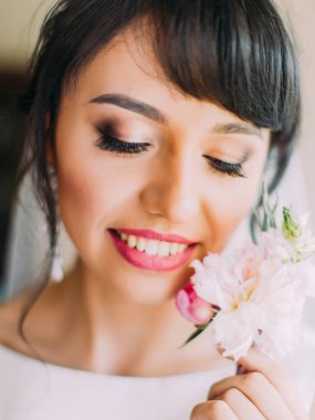 Gülümseyen gelin pembe Gül yaka çiçeği tutar. Yakın çekim portre.