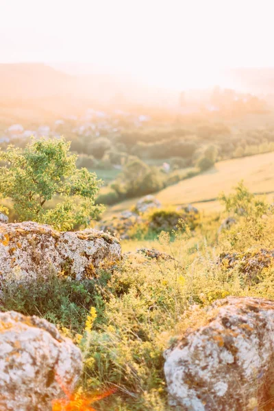 A magnífica paisagem das rochas coberto com grama verde e iluminado com o pôr do sol . — Fotografia de Stock