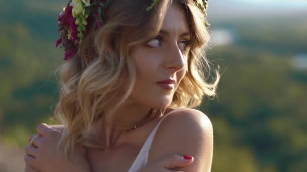Het sentimentele portret van mooi meisje met de krans van bloemen op haar hoofd in de bergen — Stockvideo