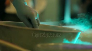 Adam çelik kabın içinde bir şeyler hazırlar