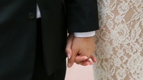 Groom in black suit holds brides hand tender — Stock Video