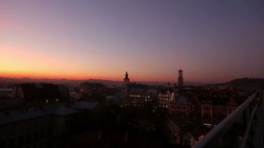 Akşam gökyüzü şehri kapsayan, çatılar üzerinden bakmak