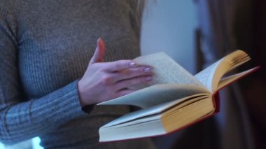 Kız el kitabı tutarak ve sayfaları çevirme.