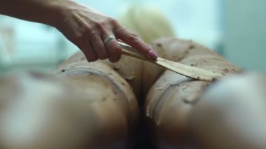 Kozmetik tedavi vücut için çamur. Doktor çamur koyarak iken kadın yatıyor.