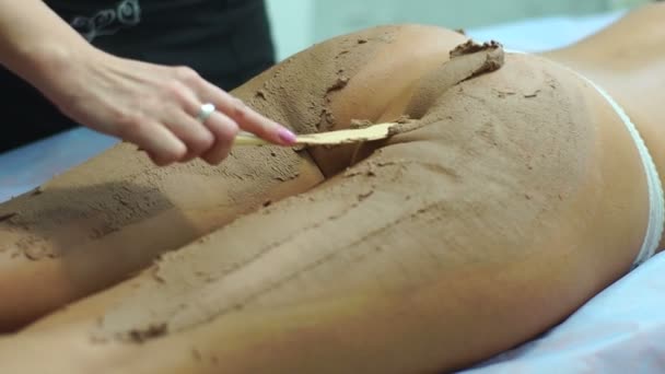 Moddertherapie voor de jonge vrouw. Zijaanzicht van de close-up van de benen. — Stockvideo