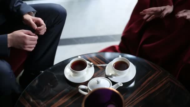 The couple sitting in the restaurant during the coffee break. The hands gesture during the conversation. — Stock Video